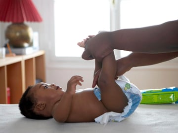 Putting on a diaper after applying nappy cream